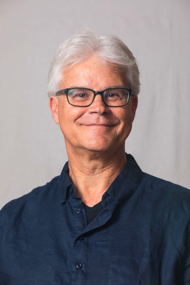 Portrait of Patrick Peterhans, smiling, in a navy shirt